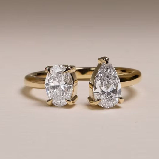 Two diamond rings with gold bands on a beige background